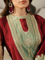 Elegant maroon ethnic outfit with traditional gold threadwork and a contrasting mint green shawl.