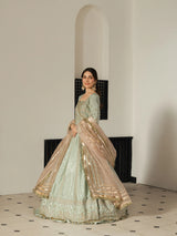 Elegant mint green Pakistani formal dress with intricate gold embroidery.