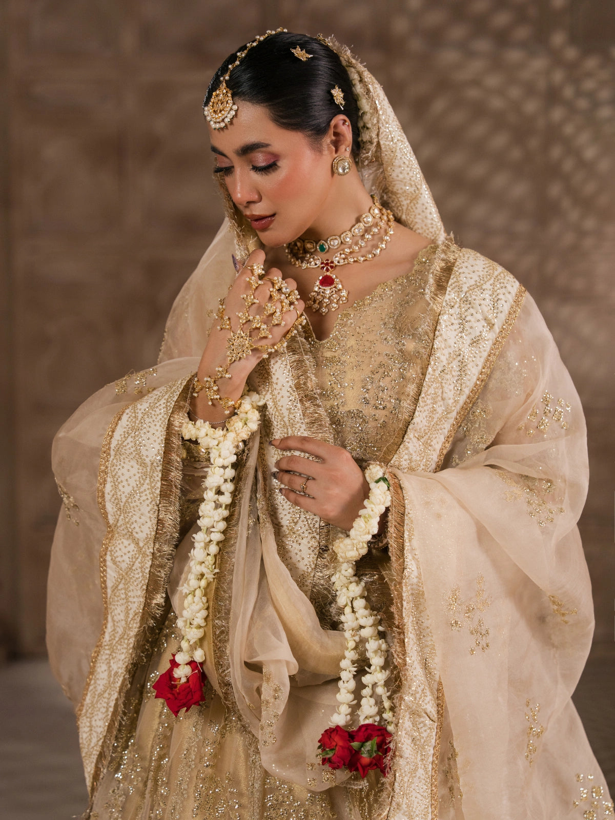 Golden bridal lehenga styled with bridal jewelry and floral garlands