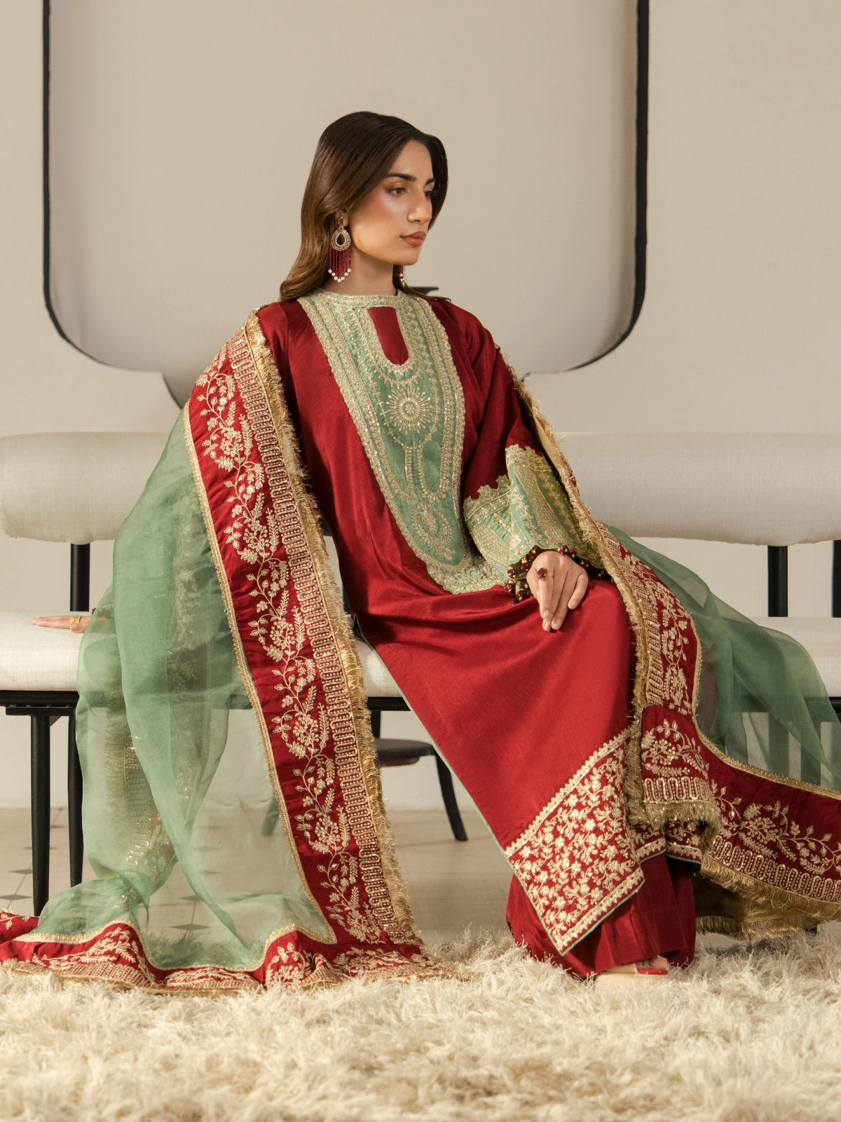 Maroon party wear suit with embroidered bell sleeves and a detailed gold hem.