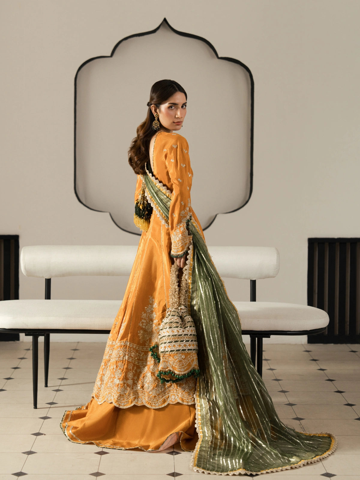 Elegant orange Pakistani maxi with embroidered bodice, sleeves, and hem.