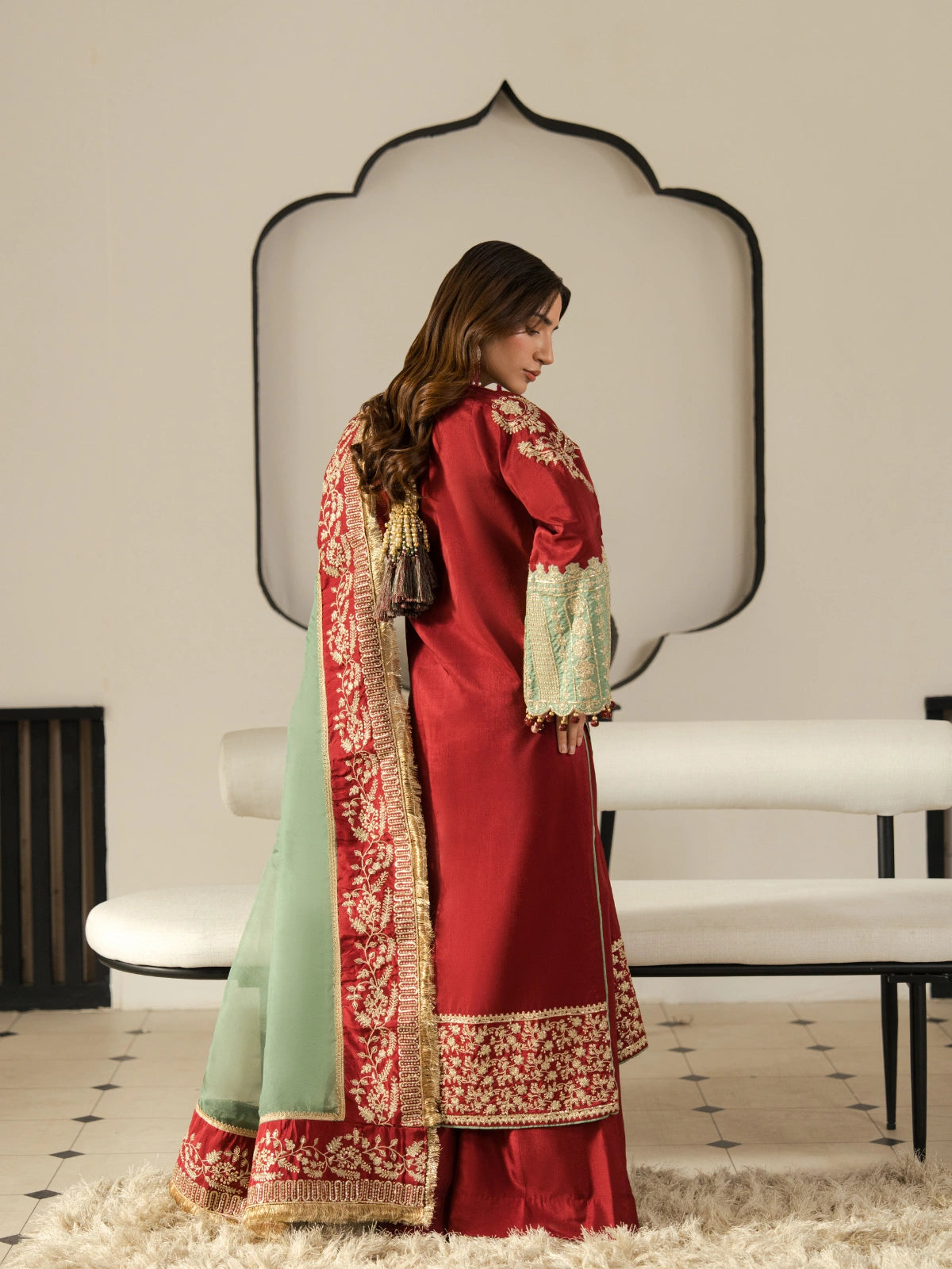 Women's maroon formal suit with gold embroidery, matching trousers, and mint green dupatta.
