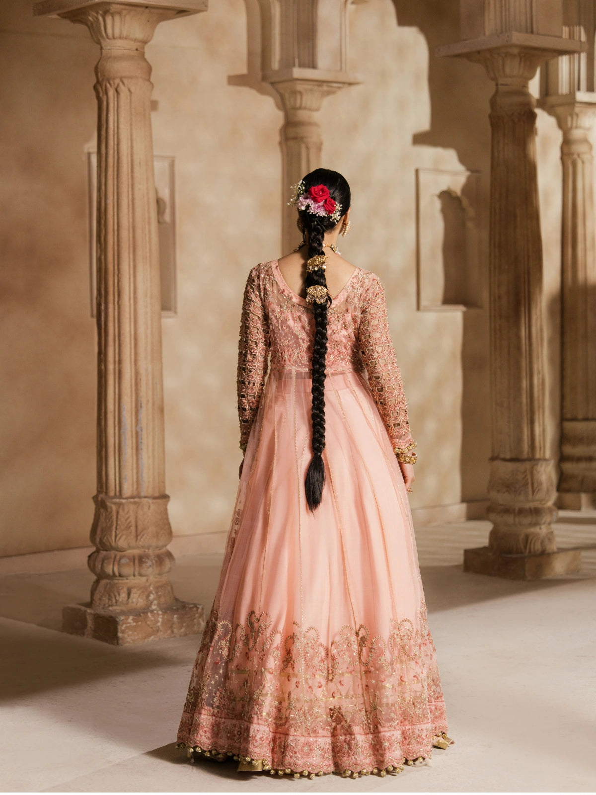 Pakistani bridal wear featuring gold floral embroidery and pink fabric