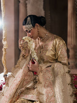 Bridal fashion featuring a gold outfit photographed in a traditional palace setting