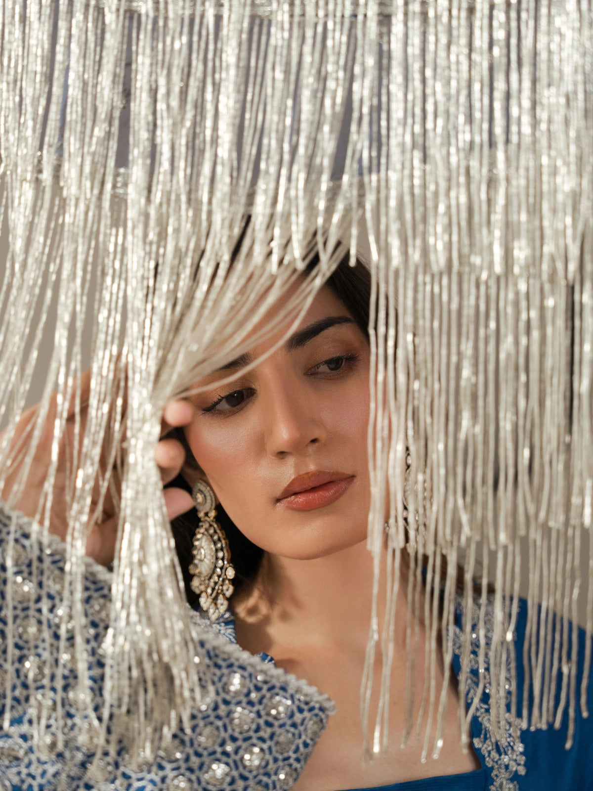 Close-up of silver embroidery on a royal blue women's formal kurta.