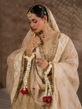 Golden bridal lehenga styled with bridal jewelry and floral garlands