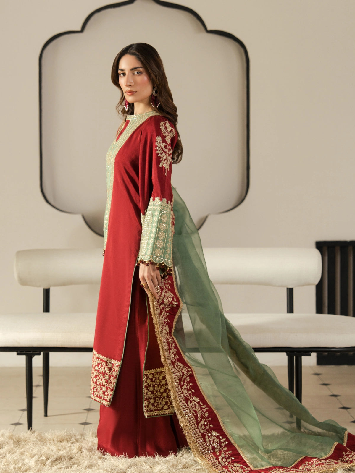 Luxury Pakistani maroon dress featuring a heavily embroidered neckline and wide embellished sleeves.