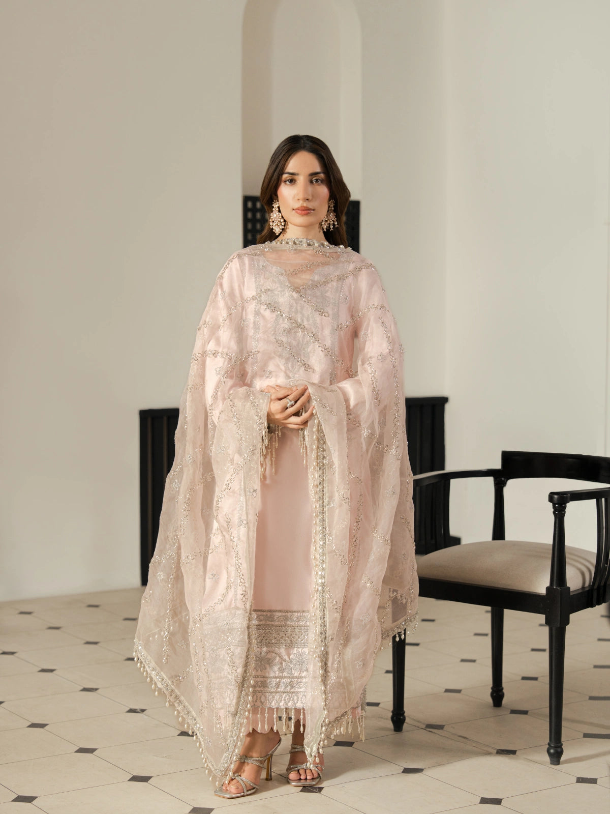 Elegant pastel pink kurta featuring silver embroidery and decorative tassels.
