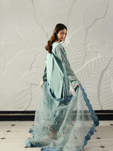 Elegant sage green Pakistani dress with intricate silver embroidery and decorative pearl tassels.